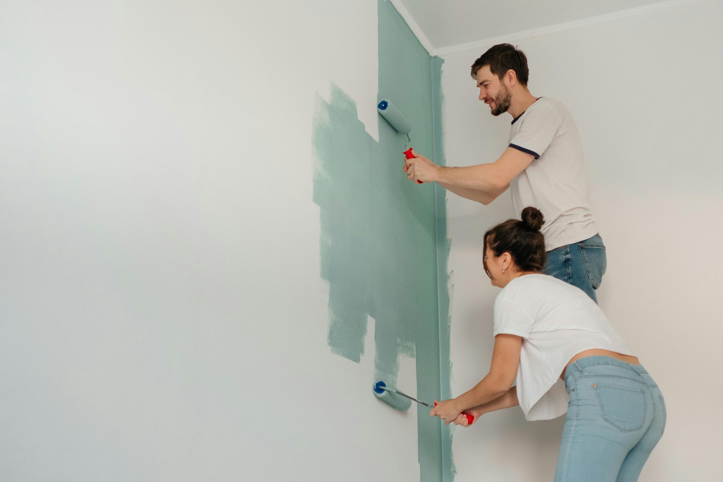 Two people painting a wall