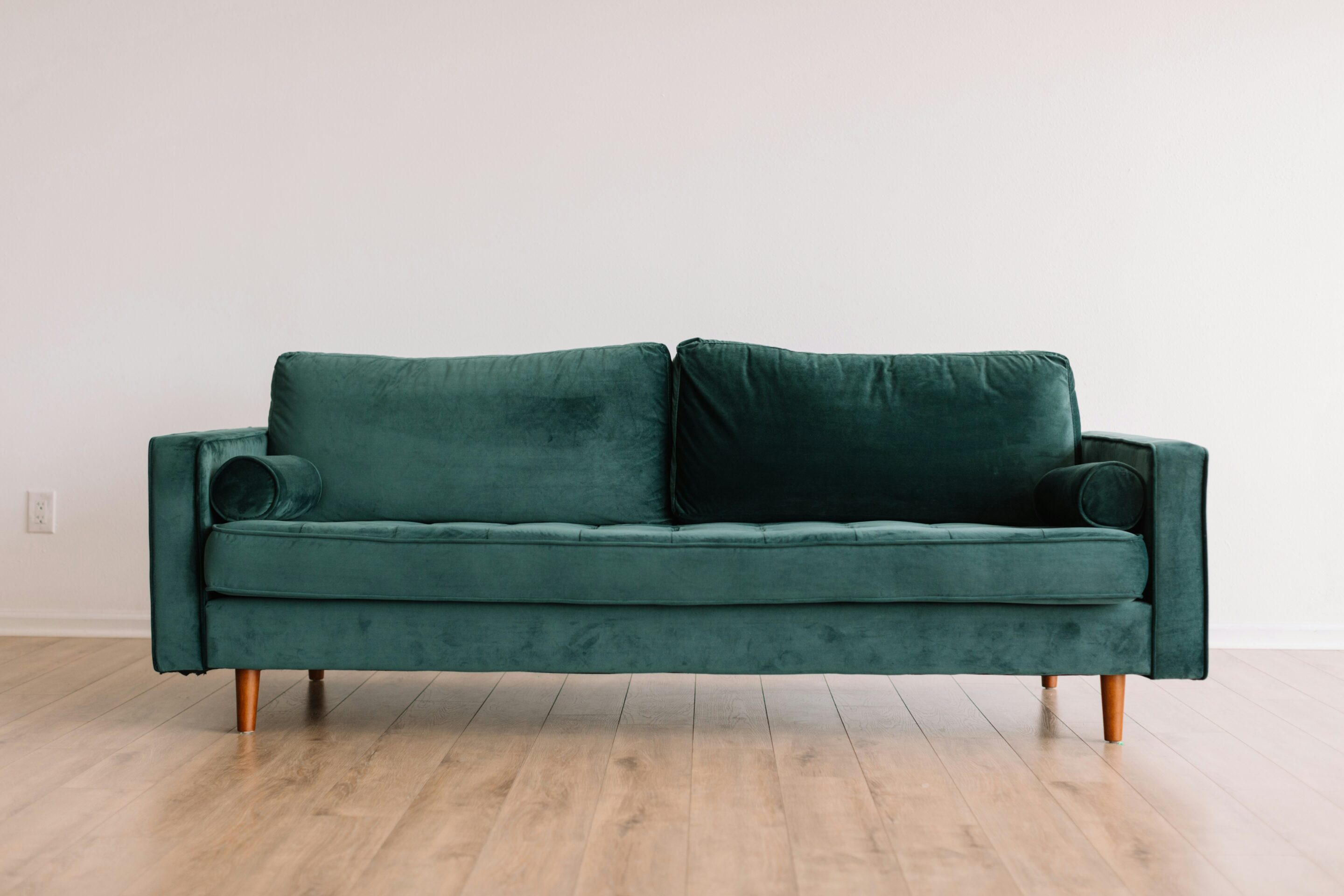 A green sofa placed in the middle of the room