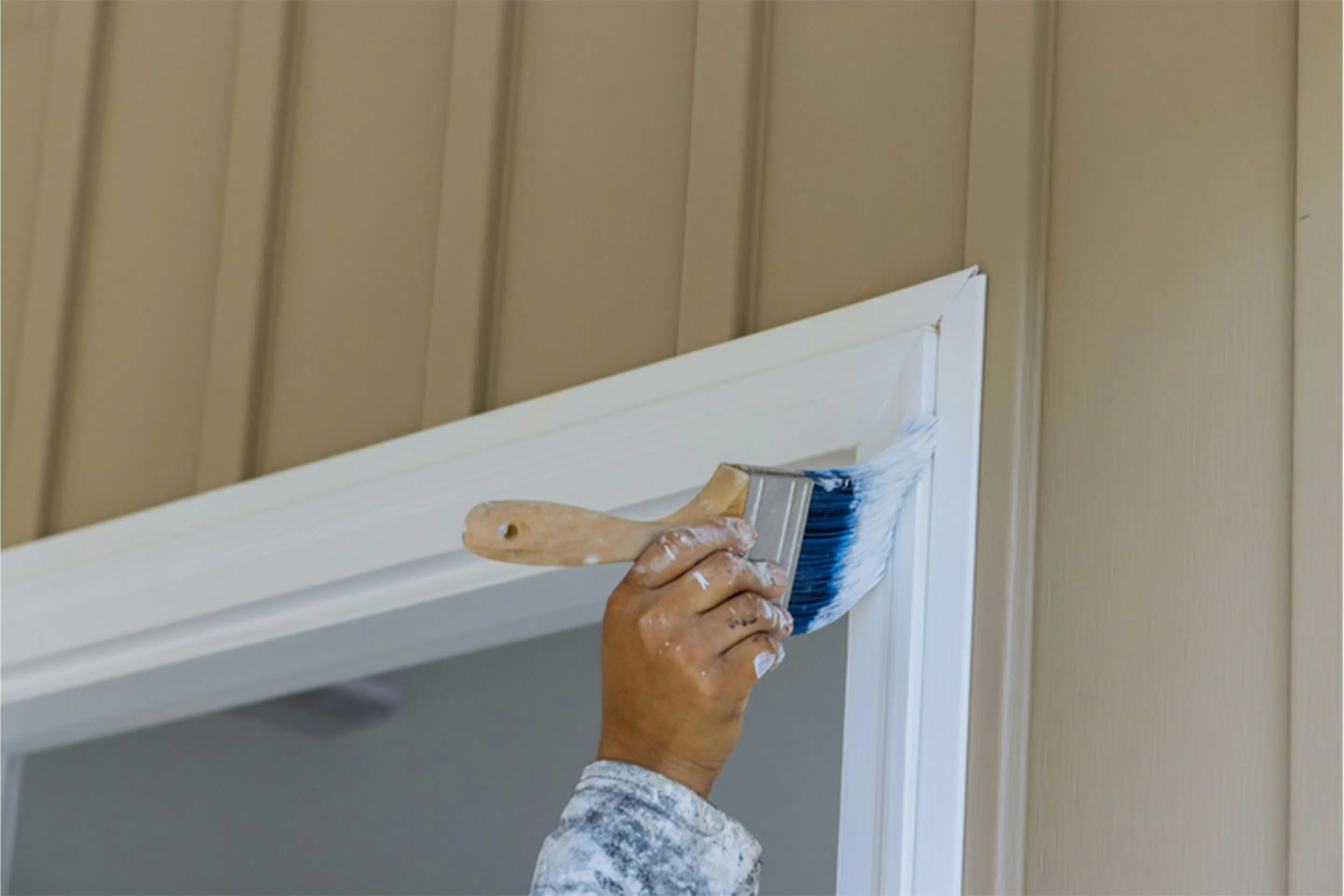 A second coat of paint going onto a house.